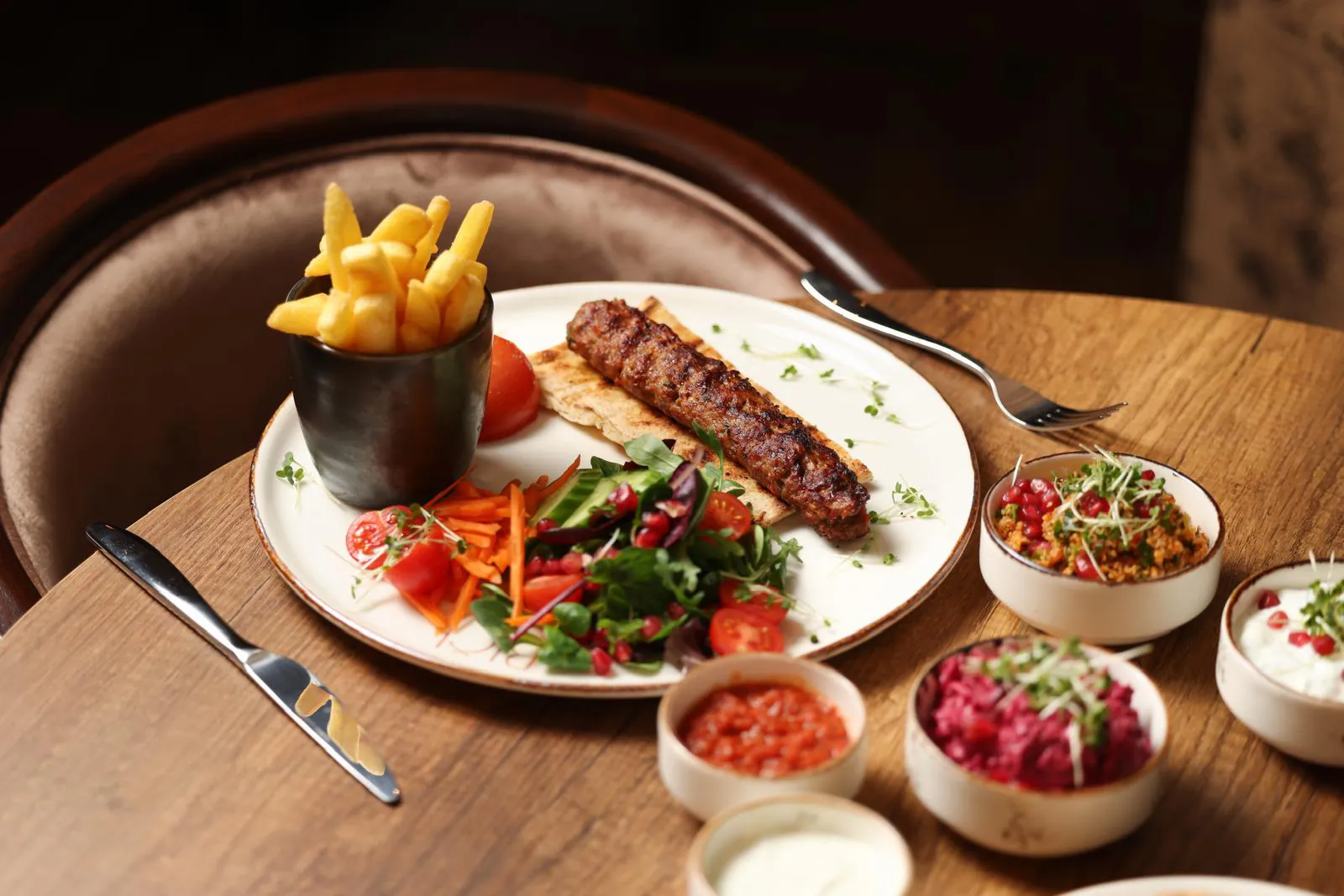 Adana kebab from the charcoal grill with salad and meze