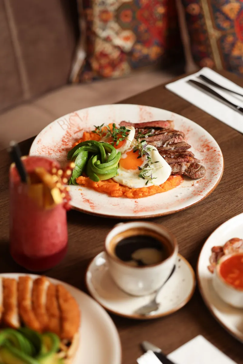 Brunch plates, smoothie and coffee on a Bici table