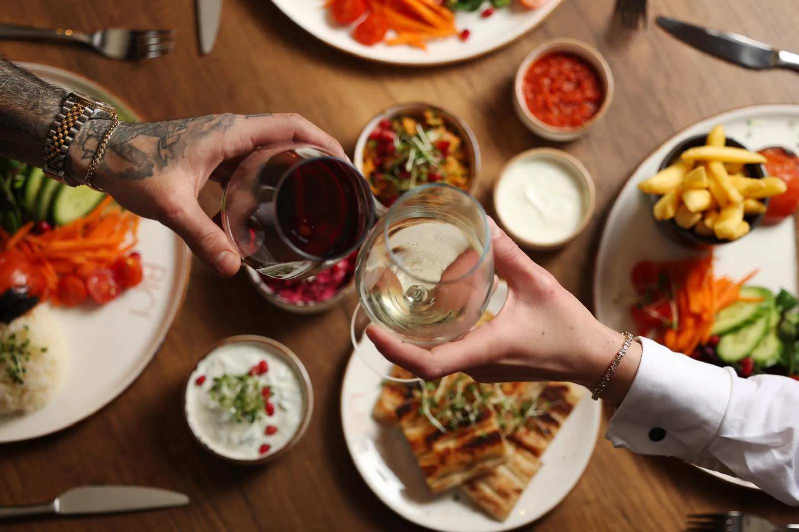 Guests raising glasses over a table of meze