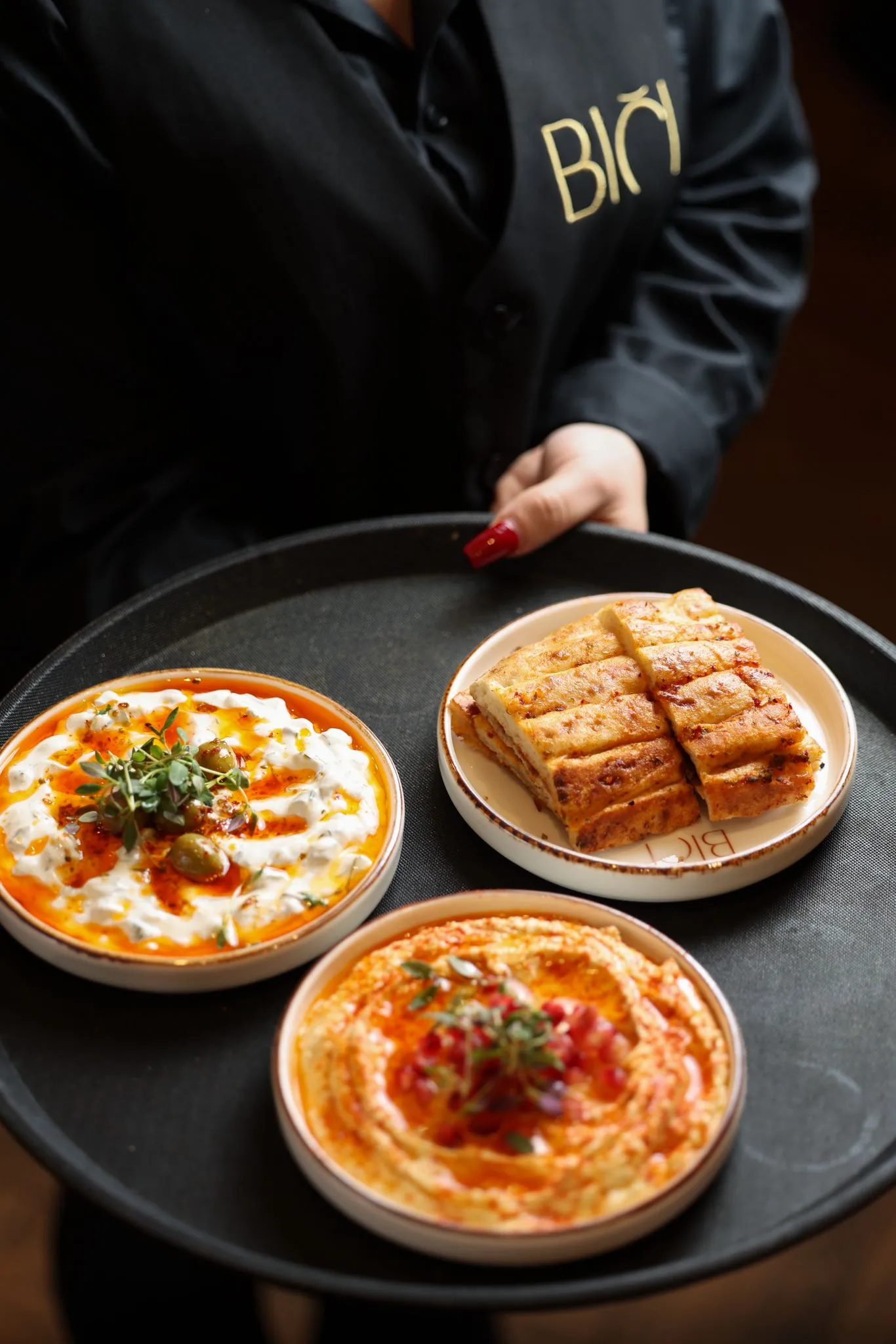 A tray of hot and cold meze carried to the table